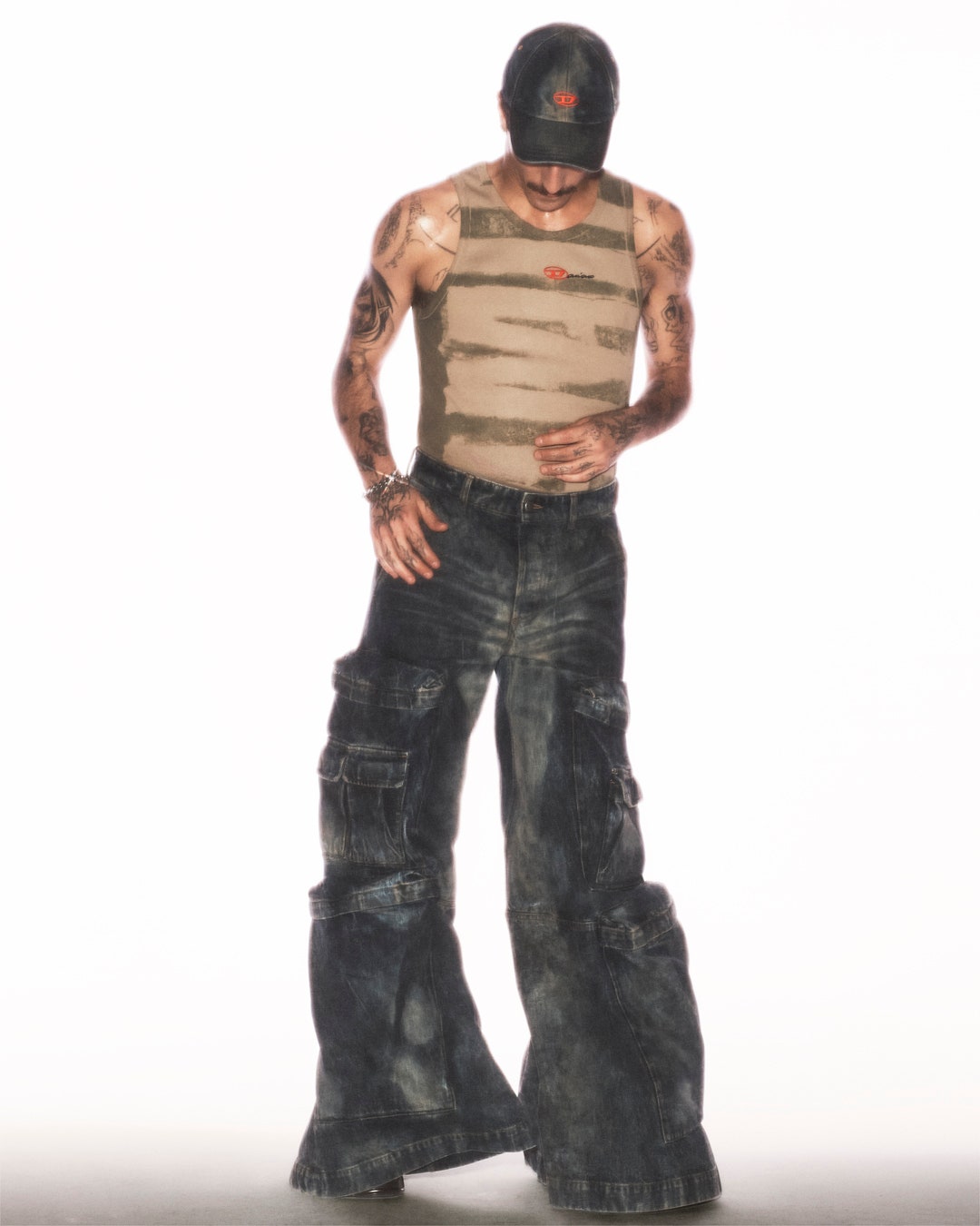 Image may contain Clothing Pants Vest Jeans Adult Person Figurine Standing Skin and Tattoo