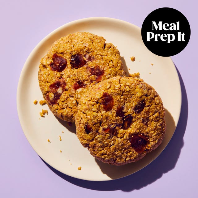 two oatmeal cookies on a plate against a purple background