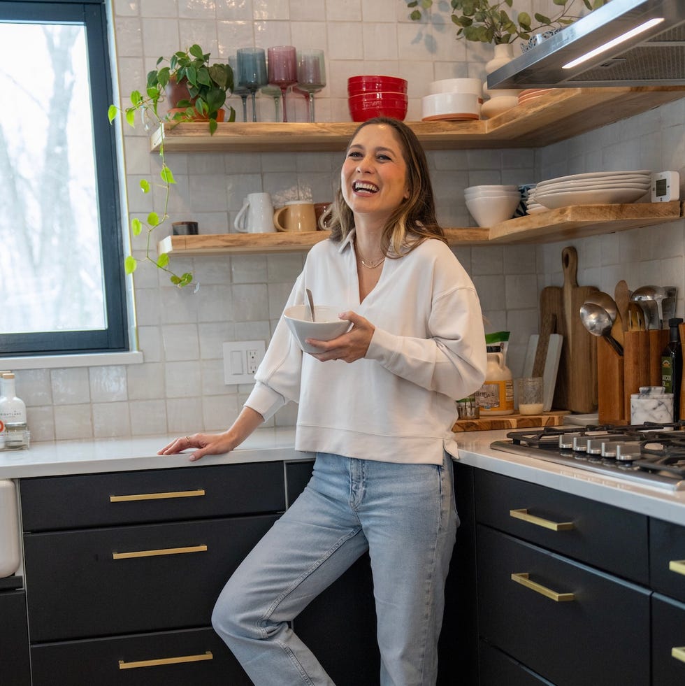 woman standing in a modern kitchen holding a bowl