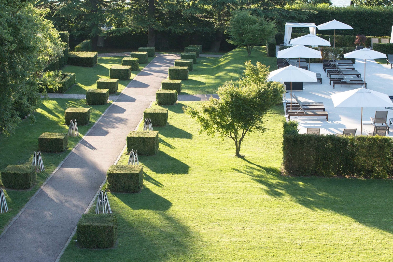 Image may contain Grass Plant Nature Outdoors Park Lawn Fence Hedge Chair Furniture Garden and Architecture