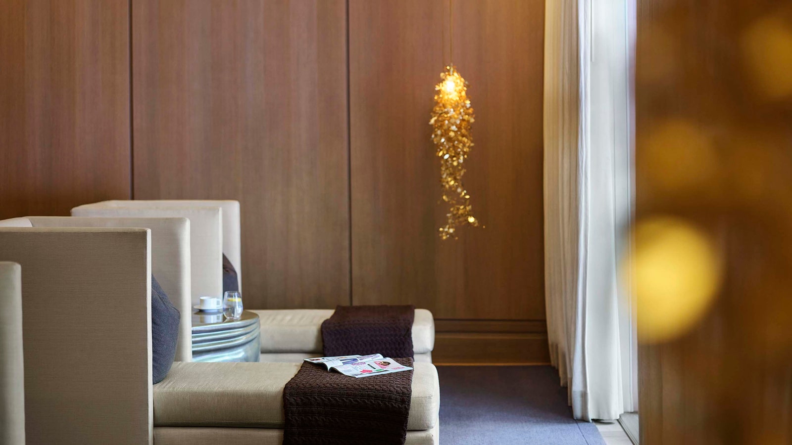 Image may contain Indoors Interior Design Book Publication Wood Panels Couch Furniture Chandelier and Lamp
